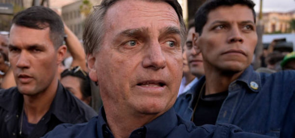 Brazil's President Jair Bolsonaro is escorted by bodyguards as he is greeted by supporters during a re-election campaign rally, at Praca da Liberdade in Belo Horizonte, Minas Gerais State, Brazil, on August 24, 2022. (Photo by Douglas MAGNO / AFP) (Photo by DOUGLAS MAGNO/AFP via Getty Images)