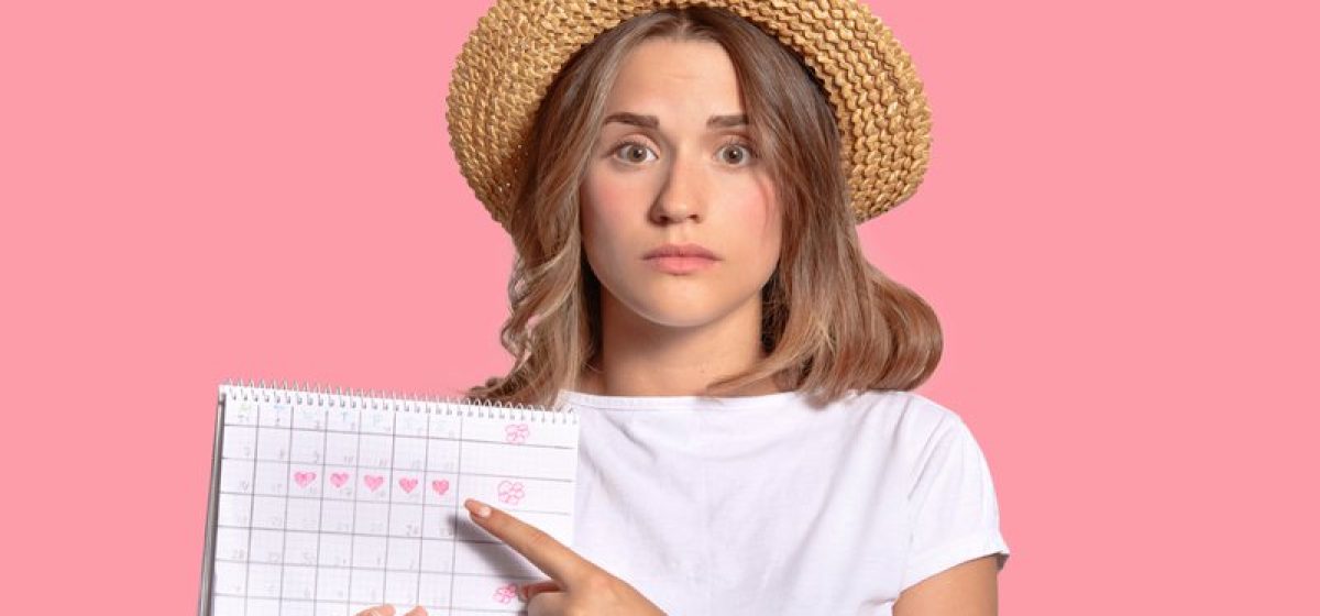 woman-with-appealing-look-holds-periods-calendar-checking-menstruation-days-points-with-fore-finger_1_widelg